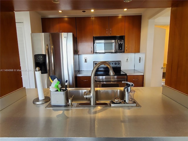 kitchen featuring appliances with stainless steel finishes, stainless steel counters, and tasteful backsplash