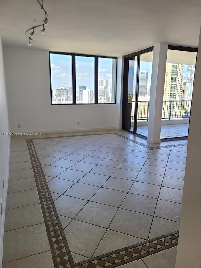 spare room featuring track lighting and light tile floors