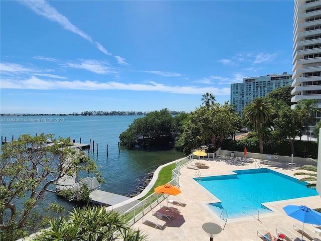 view of swimming pool featuring a patio and a water view