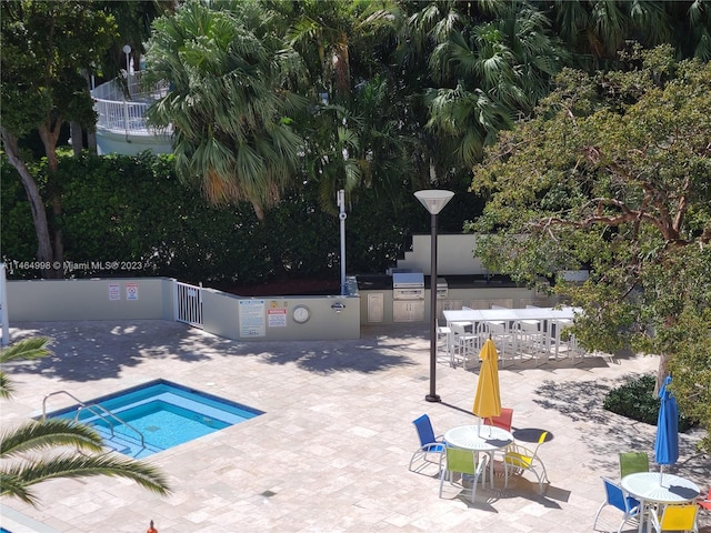 view of pool featuring a grill, an outdoor kitchen, and a patio area