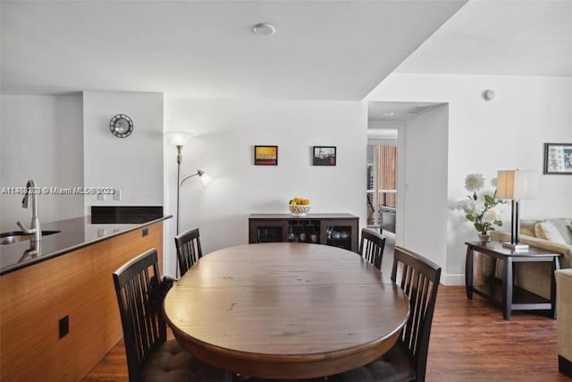 dining area with dark wood-type flooring and sink