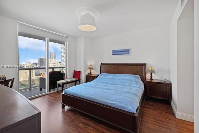 bedroom with access to outside and dark hardwood / wood-style floors