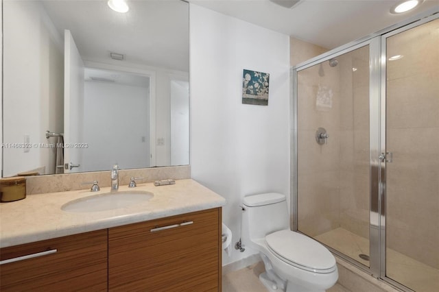 bathroom with walk in shower, toilet, and vanity with extensive cabinet space