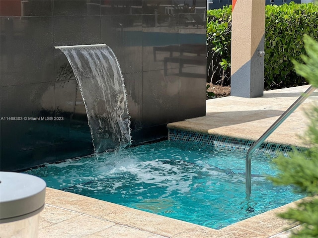 view of swimming pool with pool water feature