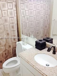 bathroom with vanity with extensive cabinet space and toilet