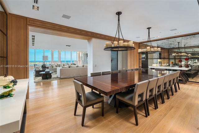 dining space featuring light hardwood / wood-style floors and crown molding