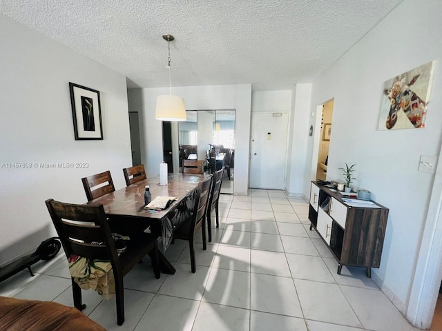 dining area with light tile floors and a textured ceiling