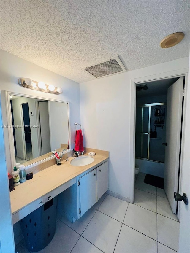 bathroom with oversized vanity, toilet, a textured ceiling, and tile flooring