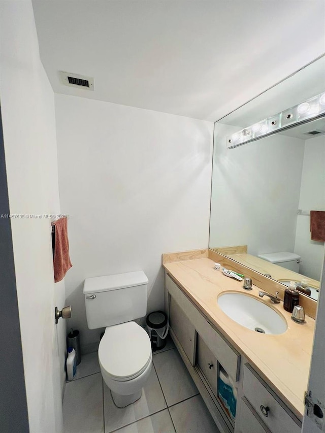 bathroom featuring vanity, tile flooring, and toilet