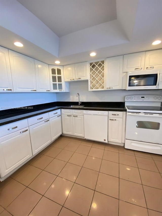 kitchen with light tile floors, white appliances, white cabinetry, and sink