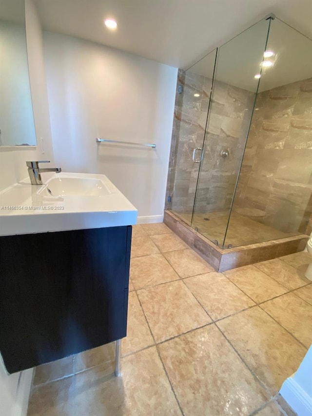 bathroom with tile floors, toilet, walk in shower, and vanity