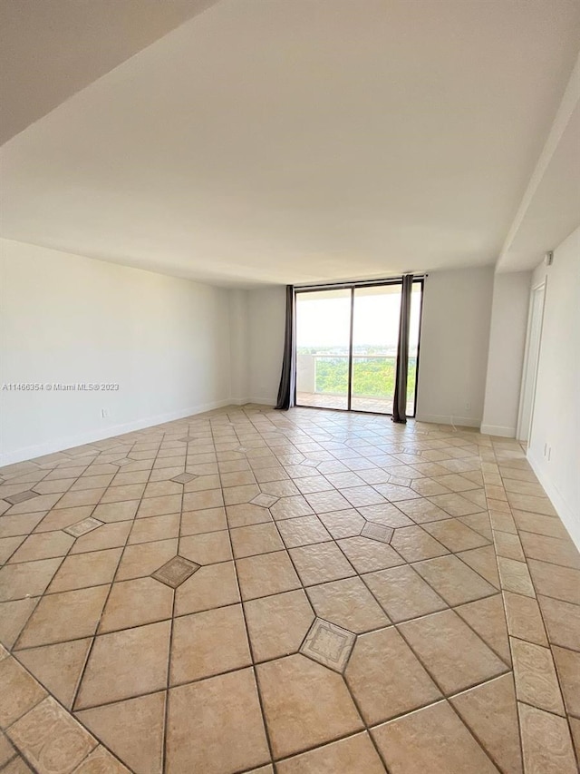 tiled spare room with expansive windows