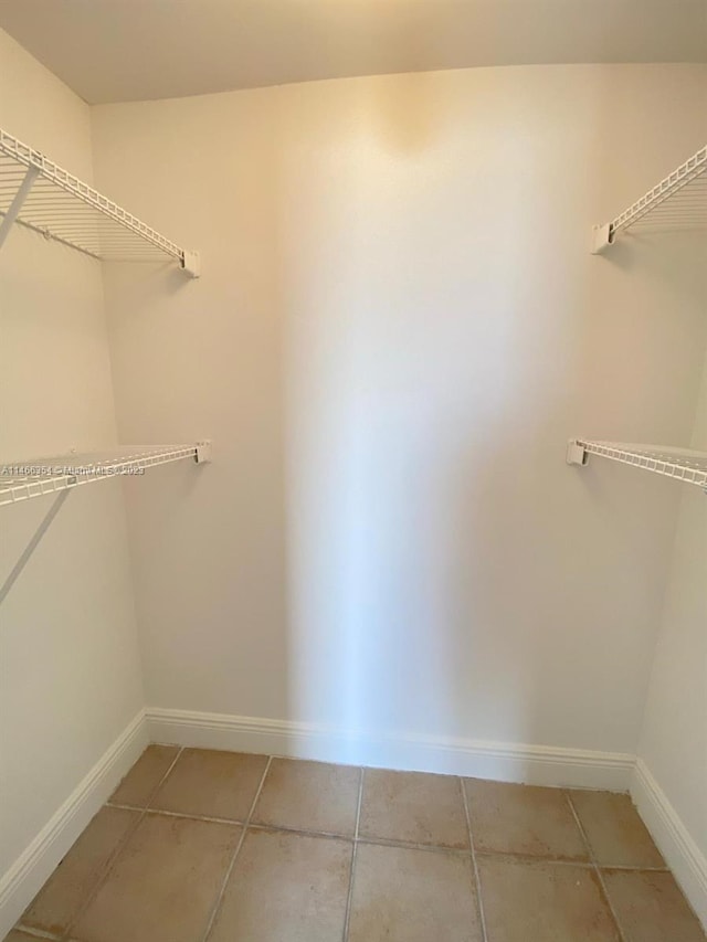 walk in closet featuring light tile floors