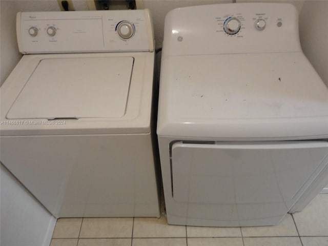 laundry room with washer hookup, light tile floors, and washer and clothes dryer