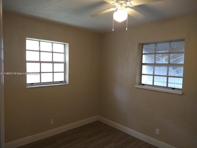 unfurnished room with dark hardwood / wood-style flooring, ceiling fan, and a wealth of natural light