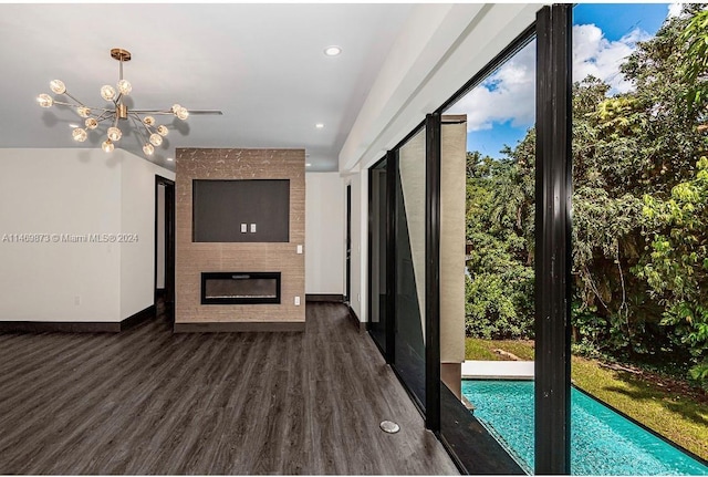 unfurnished living room featuring dark hardwood / wood-style floors, a notable chandelier, and a fireplace