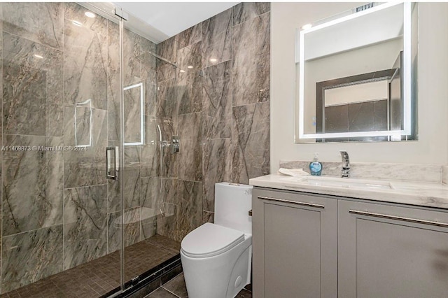 bathroom featuring vanity, a shower with shower door, and toilet