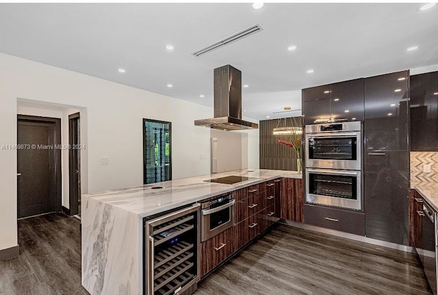 kitchen featuring island range hood, light stone countertops, dark hardwood / wood-style flooring, beverage cooler, and stainless steel double oven