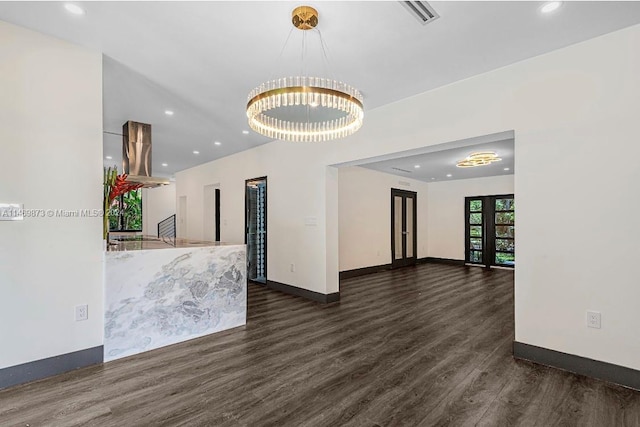 empty room with an inviting chandelier and dark hardwood / wood-style floors