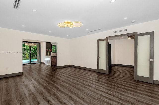 spare room featuring french doors and dark hardwood / wood-style flooring