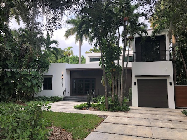 contemporary house featuring a garage and a balcony