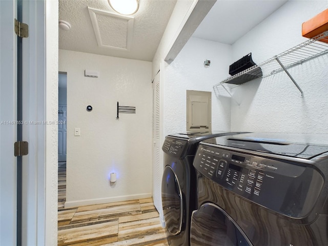 clothes washing area with hardwood / wood-style floors and independent washer and dryer