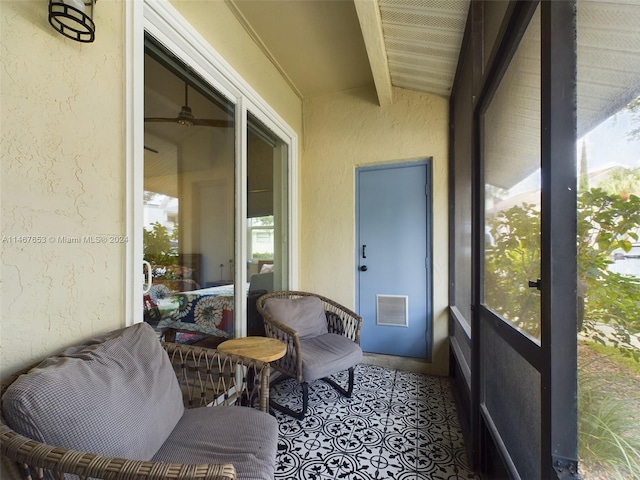 sunroom featuring lofted ceiling with beams and ceiling fan