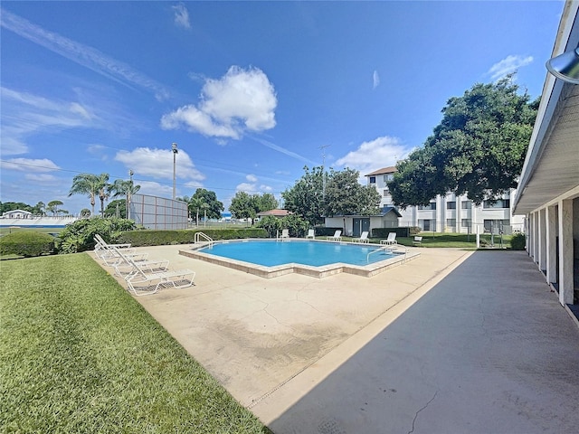 view of swimming pool featuring a patio and a lawn