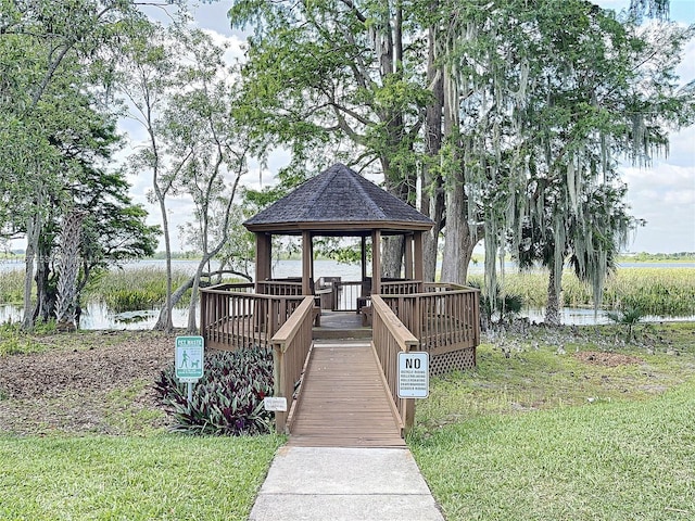 exterior space with a gazebo, a lawn, and a water view