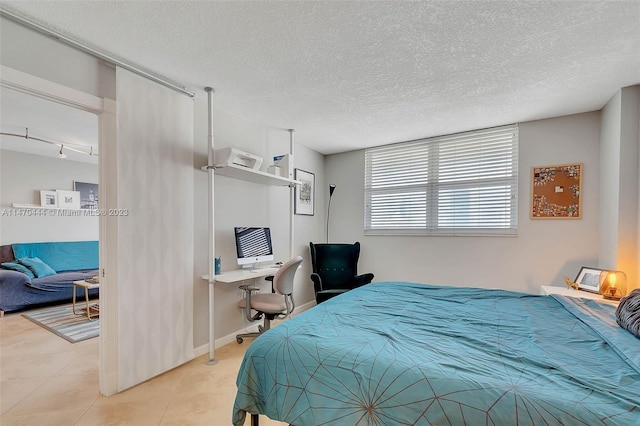 tiled bedroom featuring a textured ceiling and rail lighting