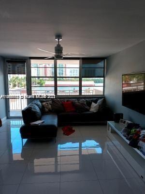 tiled living room with ceiling fan