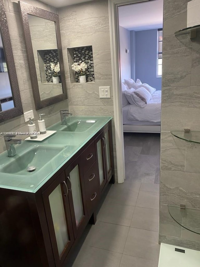 bathroom featuring tile flooring, dual sinks, and vanity with extensive cabinet space