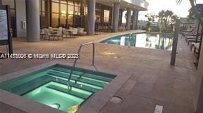 view of pool featuring a community hot tub and a patio