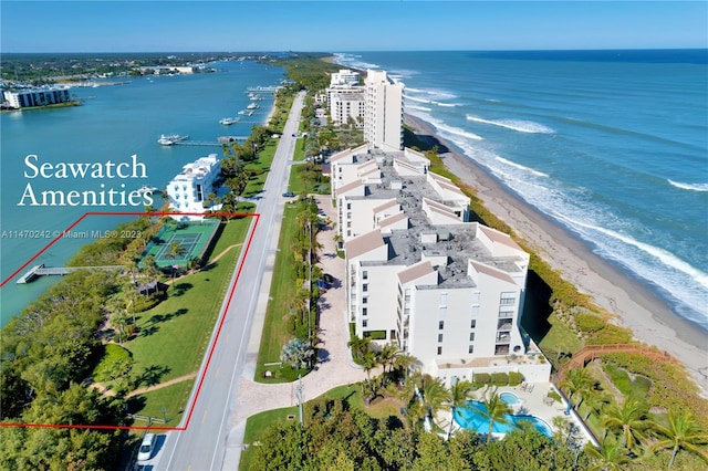 birds eye view of property featuring a water view and a beach view