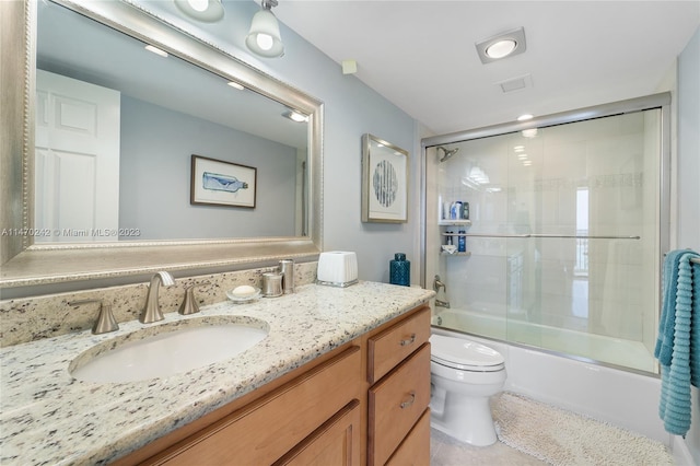 full bathroom with tile patterned floors, vanity, enclosed tub / shower combo, and toilet