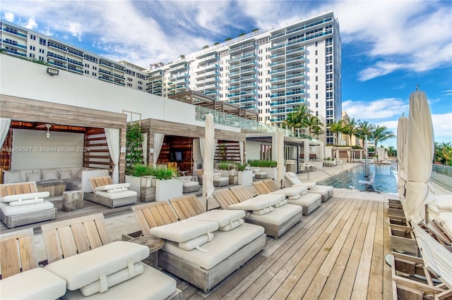 wooden deck with a community pool and an outdoor living space