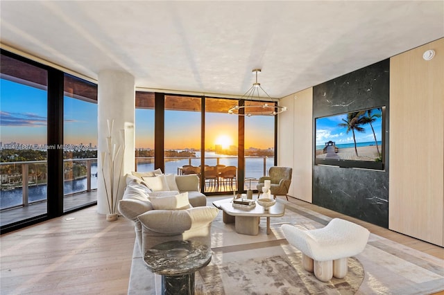 sunroom / solarium with a water view and an inviting chandelier