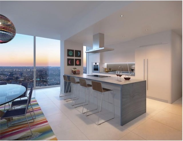 kitchen featuring floor to ceiling windows, a breakfast bar area, light tile flooring, wall chimney exhaust hood, and black electric stovetop