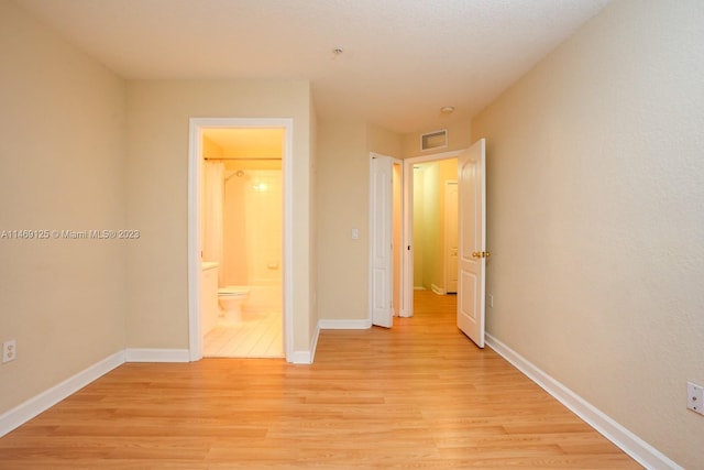 unfurnished bedroom featuring light hardwood / wood-style flooring and ensuite bath