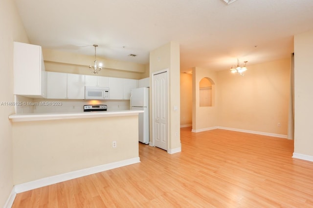 kitchen featuring white appliances, white cabinets, a chandelier, and light wood-type flooring