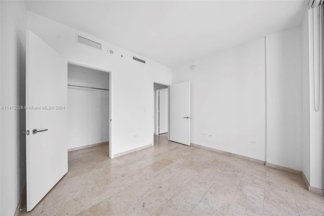 unfurnished bedroom featuring light tile floors and a closet