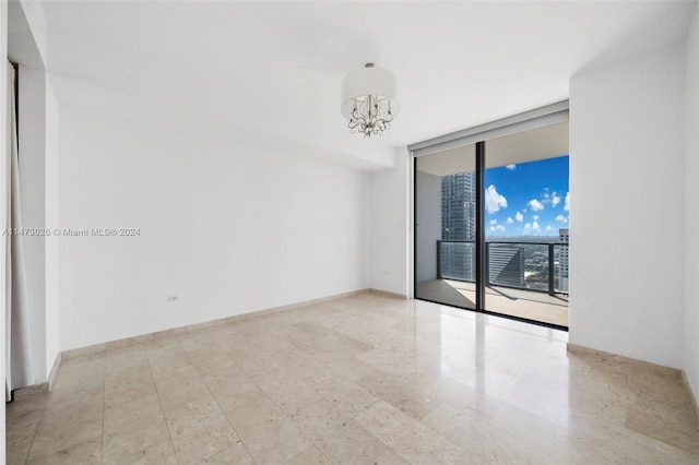 unfurnished room featuring light tile flooring, a wall of windows, and an inviting chandelier