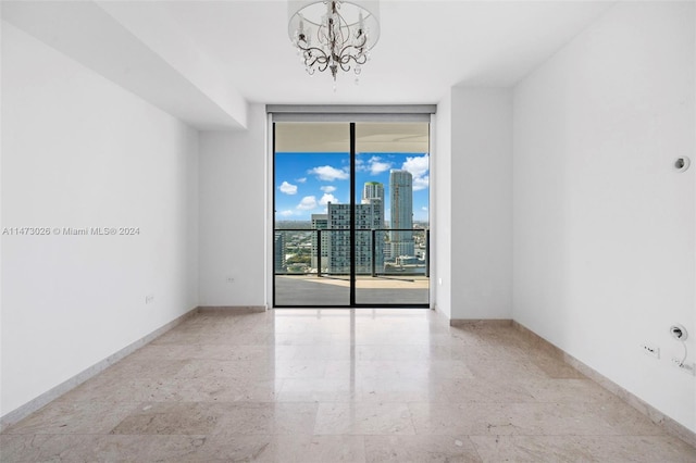 tiled empty room with a notable chandelier and expansive windows