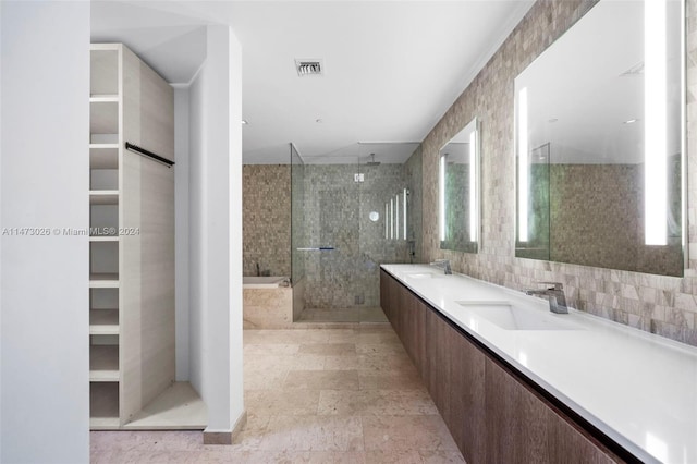 bathroom featuring tile walls, a shower with door, backsplash, tile floors, and dual vanity