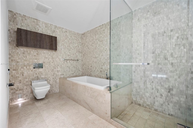 bathroom featuring plus walk in shower, tile walls, tile flooring, and toilet