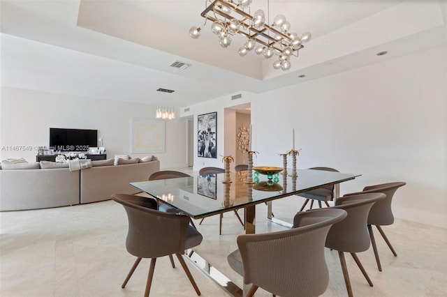 dining space featuring a tray ceiling and a notable chandelier