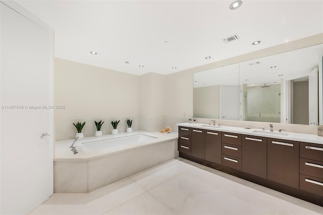 bathroom featuring vanity, tile patterned flooring, and separate shower and tub