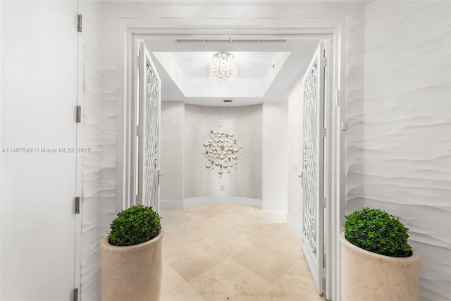 bathroom featuring a notable chandelier and a tray ceiling