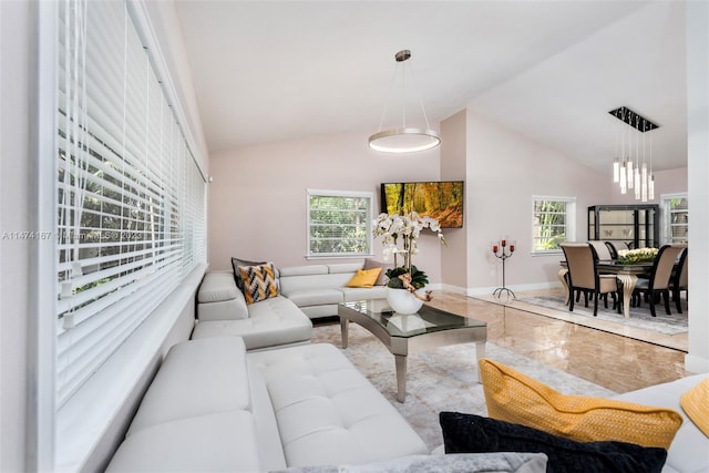 tiled living room featuring a notable chandelier, plenty of natural light, and vaulted ceiling