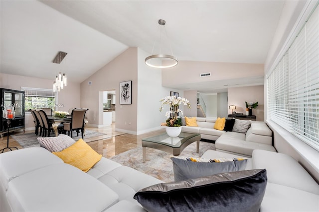 living room with light tile floors and high vaulted ceiling